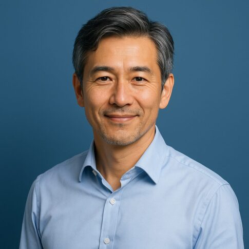 清潔感のある40〜50代日本人男性が青基調の背景で微笑んでいるポートレート