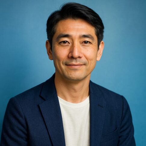 青い背景で微笑む清潔感のある40〜50代日本人男性のポートレート写真