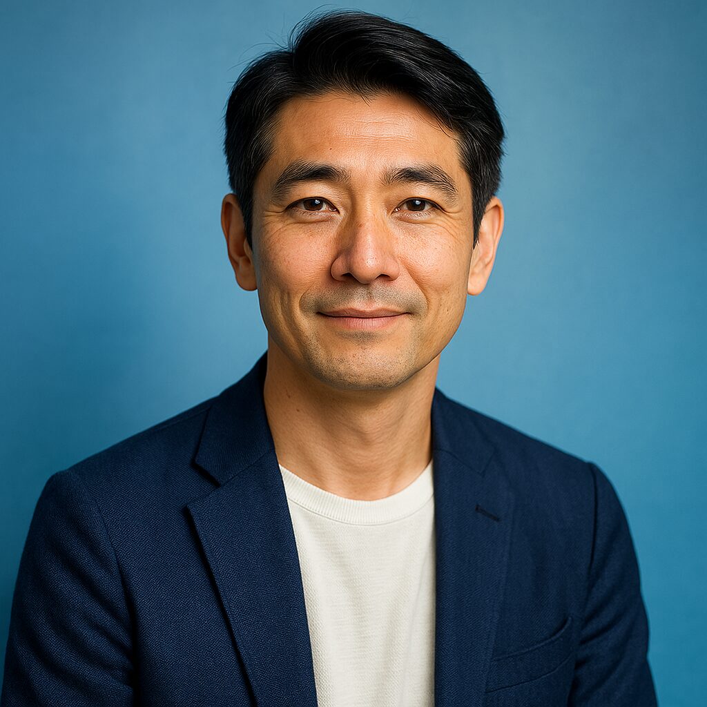 青い背景で微笑む清潔感のある40〜50代日本人男性のポートレート写真