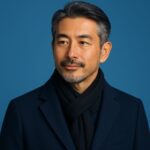 冬の婚活で好印象を与える、清潔感のある40〜50代日本人男性の上半身ポートレート。ネイビーのコートと黒マフラーを身に着けた落ち着いた印象のスタイル。