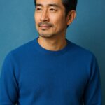 青基調の背景で清潔感のある40〜50代日本人男性が微笑む半リアル風ポートレート