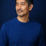 清潔感のある40代・50代日本人男性のイケオジ風ポートレート（ブルー背景）