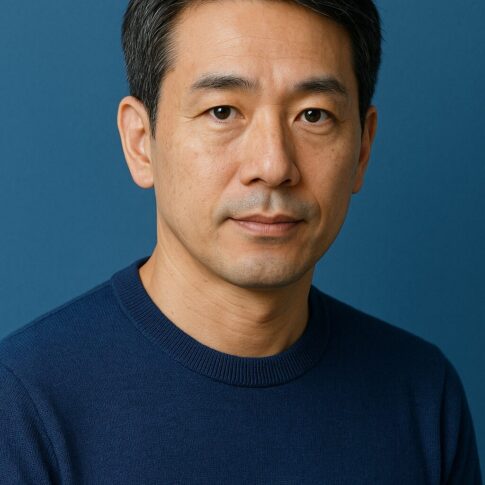 清潔感のある40〜50代日本人男性が青基調の背景で落ち着いた表情を見せるポートレート写真。年齢に合わせた自然なヘアスタイルと上品な雰囲気が伝わるイメージ。