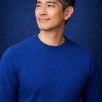 清潔感のある40代〜50代日本人男性のポートレート 深いブルー背景の半リアルアイキャッチ画像