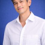 清潔感のある50代日本人男性のヘアスタイル｜青背景で爽やかな印象のミドル男性