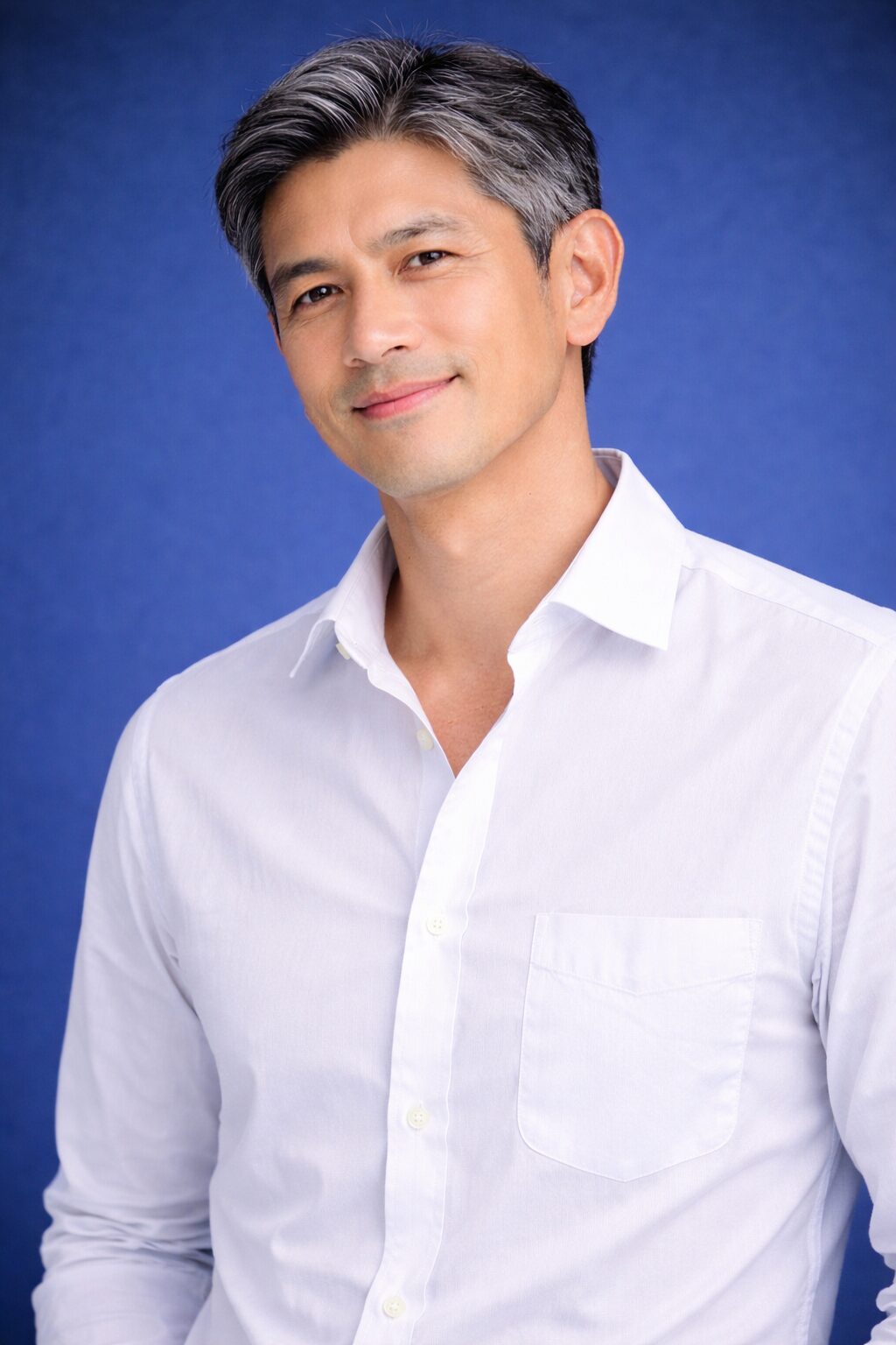 清潔感のある50代日本人男性のヘアスタイル｜青背景で爽やかな印象のミドル男性